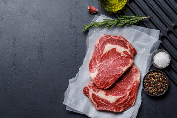 Raw ribeye steaks with savory spices