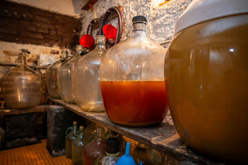 View of old fashioned wine cellar with glass storage for wine during fermentation process.