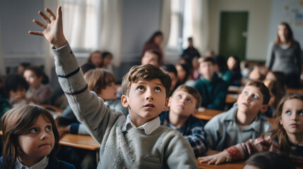 Elementary school boy raising his hand in the classroom Many students in the class were curious about the teacher's question and raised their hands to ask and ponder over how to solve the problem. - obrazy, fototapety, plakaty