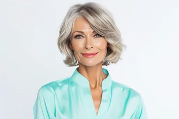 Foto op Plexiglas Portrait of beautiful well-groomed 50s mid age elderly modern woman with long bob haircut in cyan blouse on white background © Anzhela