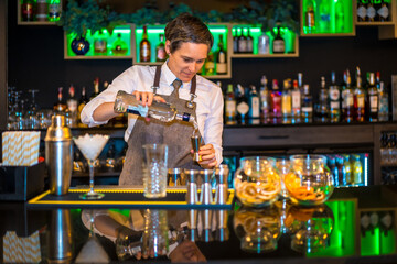Bartender using a dispenser to prepare a luxury cocktail