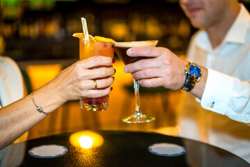 Close-up of a romantic couple toasting with cocktails