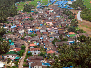 View of Alibag  Village in monsoon season at Konkan, Maharashtra, India. Traditional Indian village house surrounded by green grass and beautiful cloudy blue sky. Village landscape.