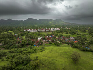 View of Alibag  Village in monsoon season at Konkan, Maharashtra, India. Traditional Indian village house surrounded by green grass and beautiful cloudy blue sky. Village landscape.