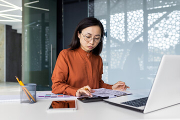 Confident serious concentrated and focused business woman behind paper work inside office, woman...