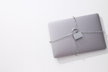 The laptop is wrapped in a chain with a lock