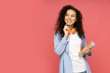 Fototapeta premium Young attractive girl with headphones on a red background