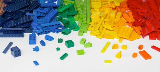 Banner. Pile of colorful rainbow toy bricks on white. Education background.