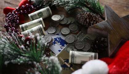 Close-up of coins banknotes and credit cards. Christmas presents and savings. Pinecones and sprig with snowflakes. Festive xmas decorations and economy concept