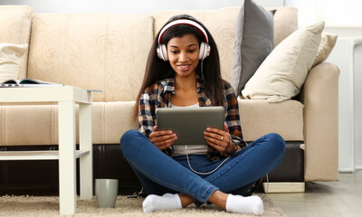 Black ordinary female american teen portrait at home sofa remote education concept. Girl hold...