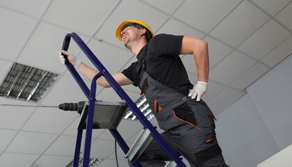 Specialist shouting from back pain holding body part. Professional handyman with bad health condition standing on metal ladder with screwdriver. Spinal aches of technician
