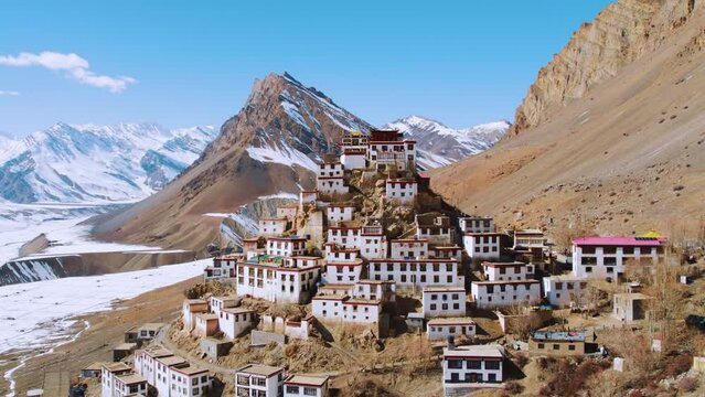 Aerial view of Key Monastery with snowy mountains in background during winter season at Kaza, Spiti Valley India. Buddhist monastery in mountains. Monastery in mountains aerial view. 4K.