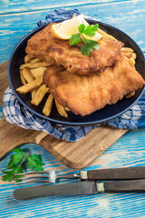 A piece of fried cod with fries on a plate.