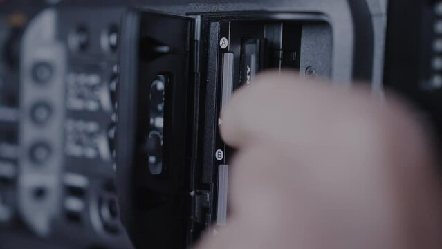 Removing the xqd card from the camera. Professional filmmaking, finishing the shoot and copying the files. 