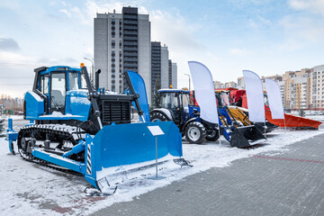 Bulldozer and wheeled tractors with mouldboard at an industrial exhibition at winter