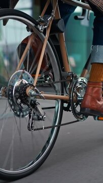 Stylish hipster man riding on vintage bicycle. follow camera, midsection shot
