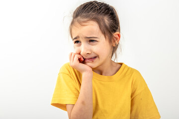 Scared and anxious girl, biting her fingernails on a white background isolated.