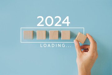 2024 New Year Loading. Loading bar with wooden blocks 2023 on blue background. Start new year 2024...