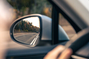 The view of the road in the car's rearview mirror.