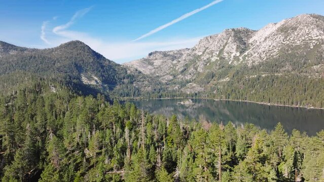 Drone beautiful forest lake aerial view California. Tahoe mountain lake with turquoise water and green trees. Blue sky reflection in water.Beautiful spring landscape with rocky mountains spruce forest