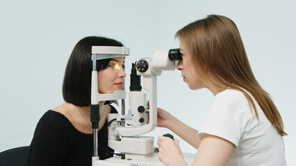 An ophthalmologist checks a young woman's vision using modern equipment. Concept for advertising ophthalmic services and medical technologies.
