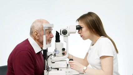 An ophthalmologist checks the vision of an elderly person using modern equipment. The concept of...
