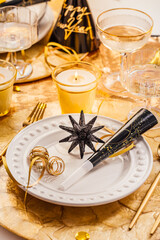 New Years Eve celebration. Holidays served table with champagne and and luxury golden cutlery, with decoration and Christmas decor