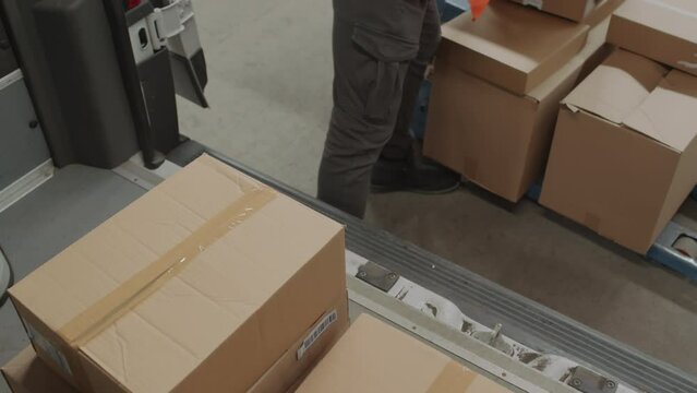 Tilt down shot of man putting packages into cargo van while working at storage office