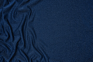 Trendy 80s, 90s, 2000s Background of draped dark blue fabric with silver lurex thread. Beautiful fashionable shiny fabric with a shiny thread for making clothes. Textile background texture.