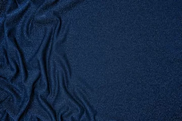 Fotobehang Trendy 80s, 90s, 2000s Background of draped dark blue fabric with silver lurex thread. Beautiful fashionable shiny fabric with a shiny thread for making clothes. Textile background texture. © Aleksandra Konoplya