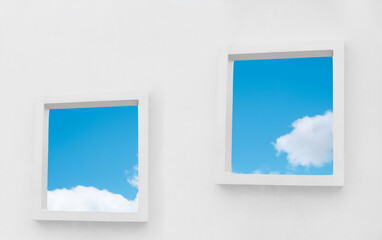 White Wall texture of concrete with open window against blue sky and clouds inSummer, Exterior Cement building with two border frame with Spring sky,Ant view Modern architecture. Minimal design