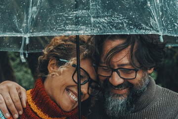 Romantic couple in love under umbrella in rainy day. Man and woman enjoy relationship and happiness...