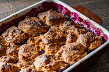 Fresh baked raspberries cobbler in a baking dish. Homemade berry cobbler, closeup