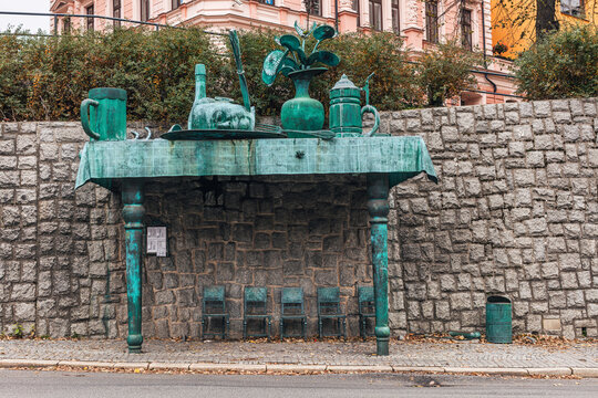 "The Giant's Breakfast"  bus stop by David Čern&yacute; in Liberec, Czech Republic. According to author, bronze items symbolize the former Czech-German-Jewish community. 