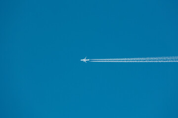 Fototapeta premium 青空を航行する飛行機とその飛跡