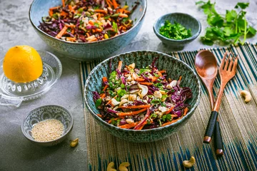 Fotobehang Red cabbage salad in Asian style with carrots, cilantro, cashew nuts and onions © Brebca
