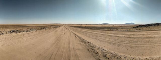 Panorama looking into the distance over a desert in Namibia, with nothing around for miles.