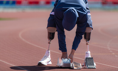 Disabled athletes prepare in starting position ready to run on stadium track
