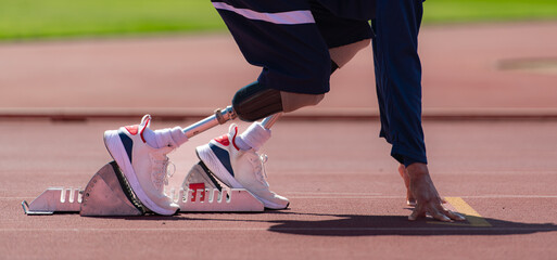 Disabled athletes prepare in starting position ready to run on stadium track