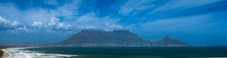 Aerial view of Cape Town's Table Mountain zoomed, with clouds billowing over the mountain on a...