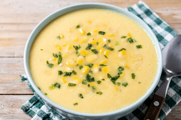 Corn soup in green bowl on wooden table. Close up