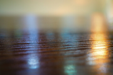 Wooden table with reflections in detail bokeh background