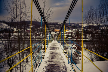 Crossing the pedestrian bridge over the river in winter.