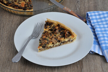 Part de tarte aux champignons maison dans une assiette avec une fourchette