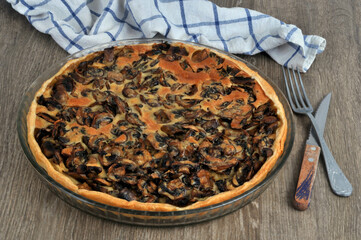 Tarte aux champignons faite maison dans un plat avec des couverts