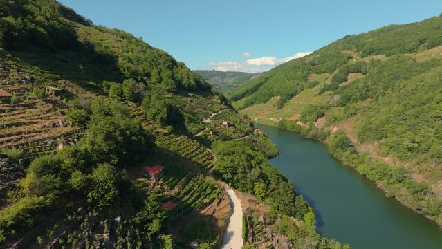 Drone footage of the terraced green mountain village on River Minho on a sunny day in Lugo, Spain