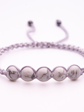 Tibetan Dzi bead. Cacholong Dzi bead Luck hook bracelet. Bracelet made of stones on hand from natural stone Cacholong. Bracelet made of natural stones. Handmade bracelets on black modern background.