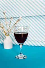 A glass of red wine on a blue background with a stripes 