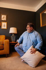 Fototapeta premium Body positive father sitting in living room and smiling