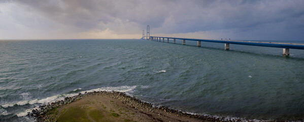 View from the coast of Denmark, one can see the Storebælt Bridge spanning across the horizon,...